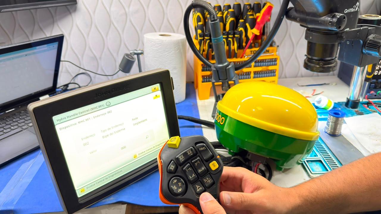 Teclado de comando sendo testado contra a tela de diagnóstico de um monitor John Deere